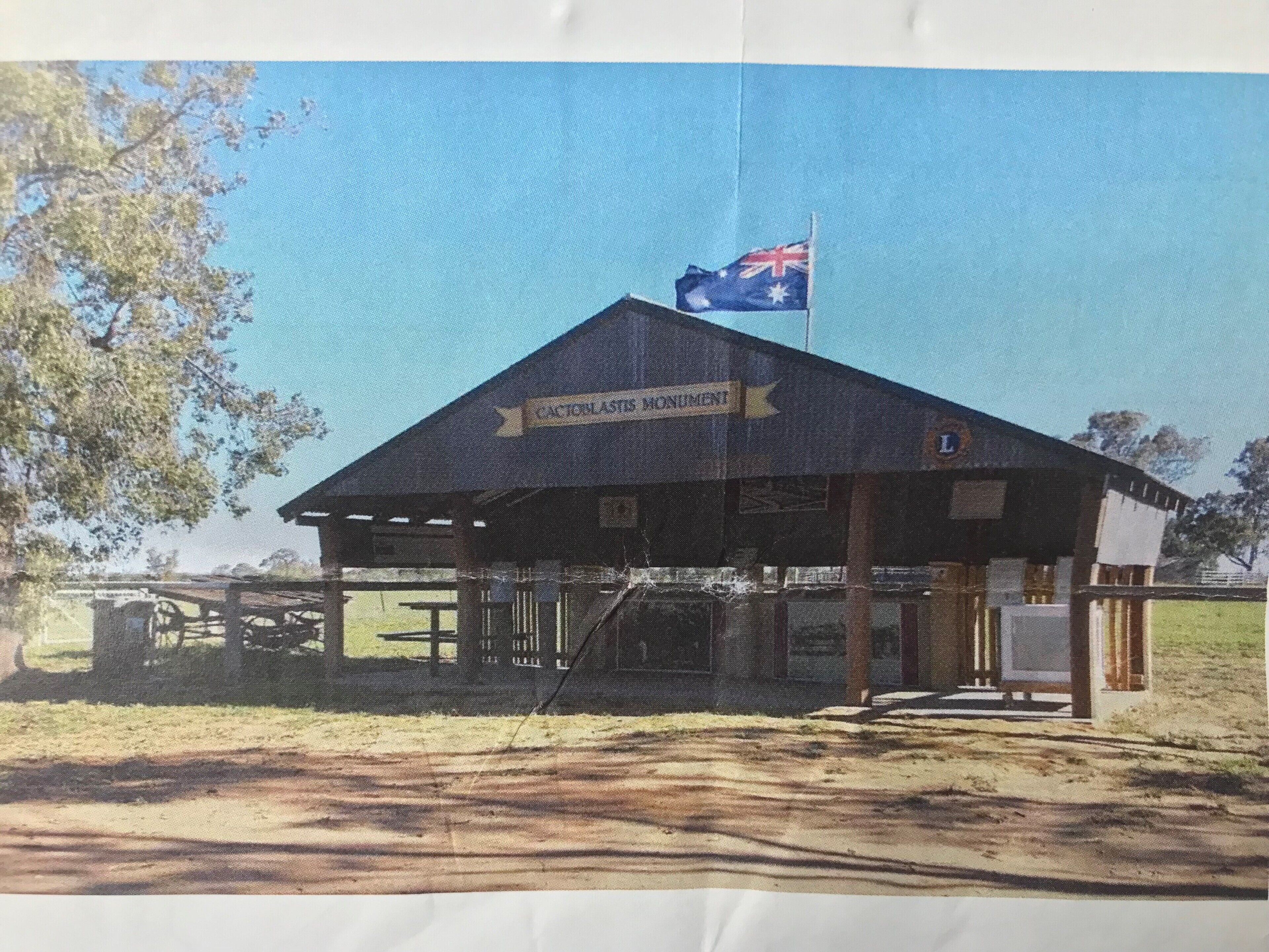 A rustic building with a sign reading "Caitlin's Monument."
