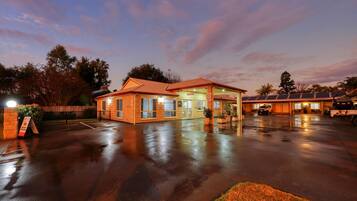 A hotel with a reception area, a parking lot, and solar panels on the roof.