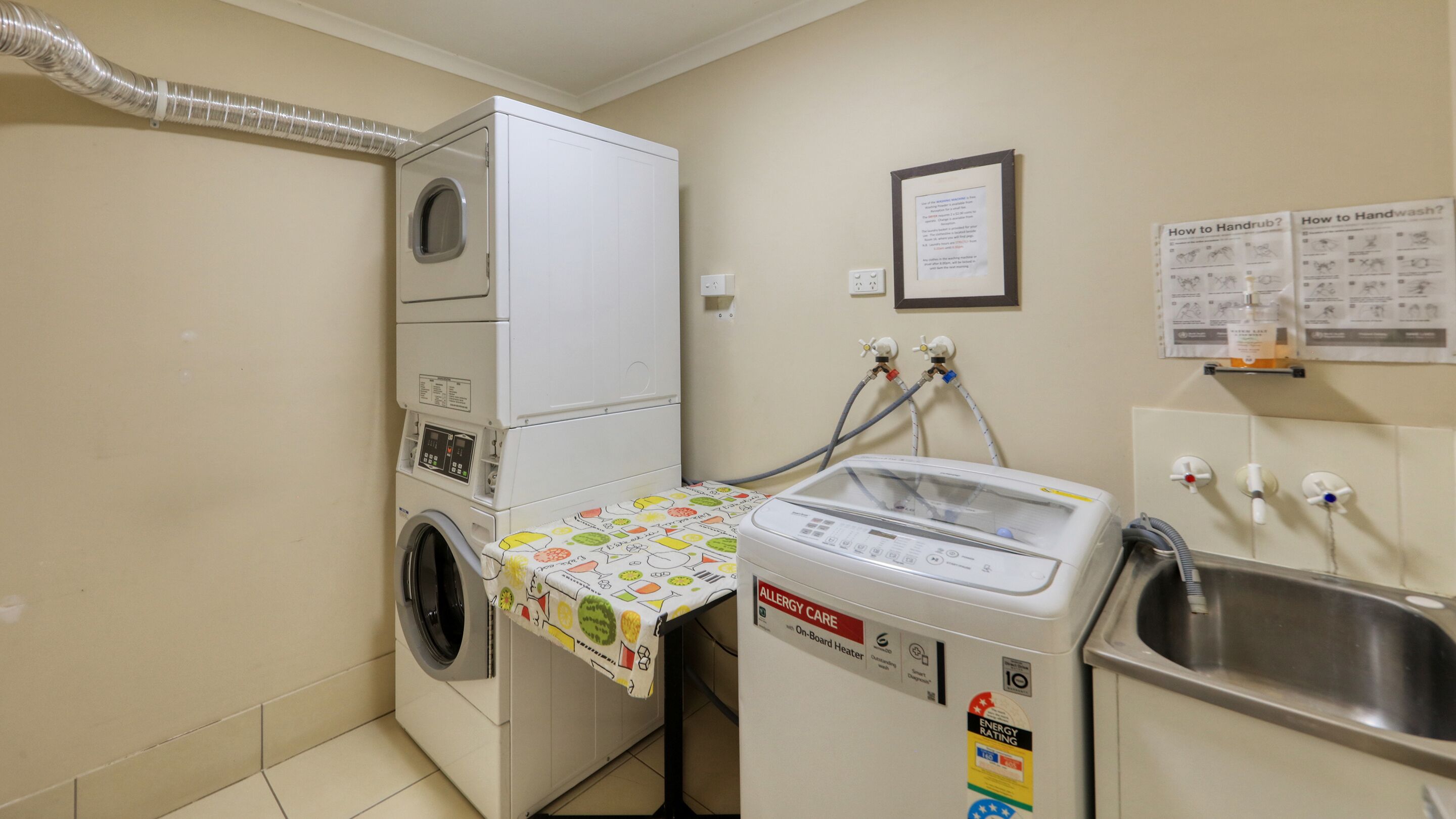 Una lavanderia dotata di lavatrice, asciugatrice e un angolo per il lavaggio a mano.