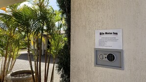 Un carrete de manguera contra incendios montado en la pared y un cartel de recogida de llaves para Silo Motor Inn.