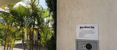 A wall-mounted fire hose reel and a key collection sign for Silo Motor Inn.