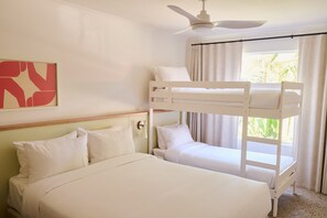 Una habitación con una cama litera, una cama individual, un ventilador de techo y una ventana con cortinas.