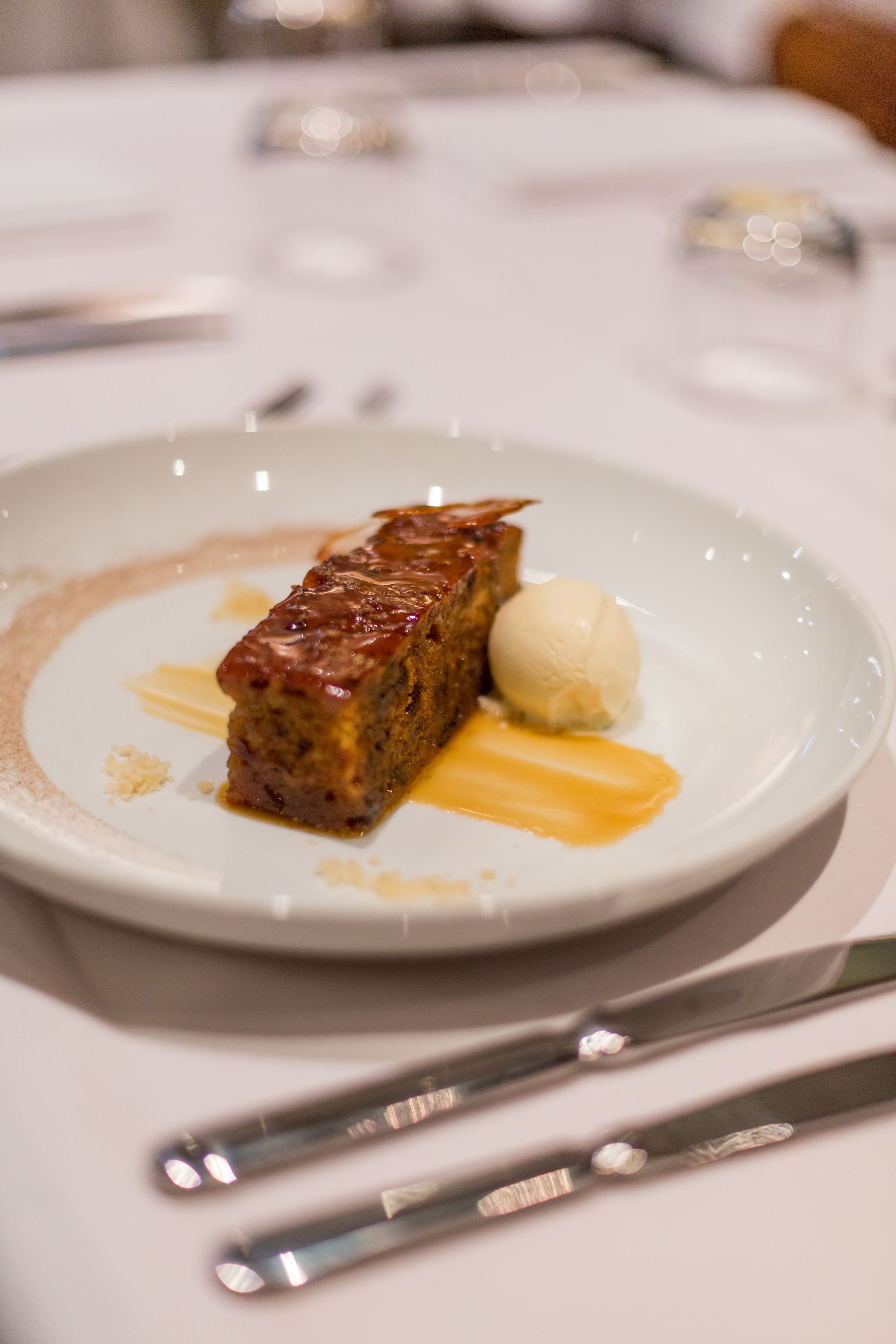 A dessert plate with a slice of cake and a scoop of ice cream on a white plate.
