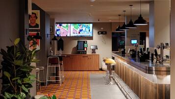 A modern bar area with a tiled floor, bar stools, and a counter.