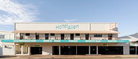 A hotel with a sign reading 'Hotel Allen' and a storefront with 'Pokies' and 'Sports Bar' signs.