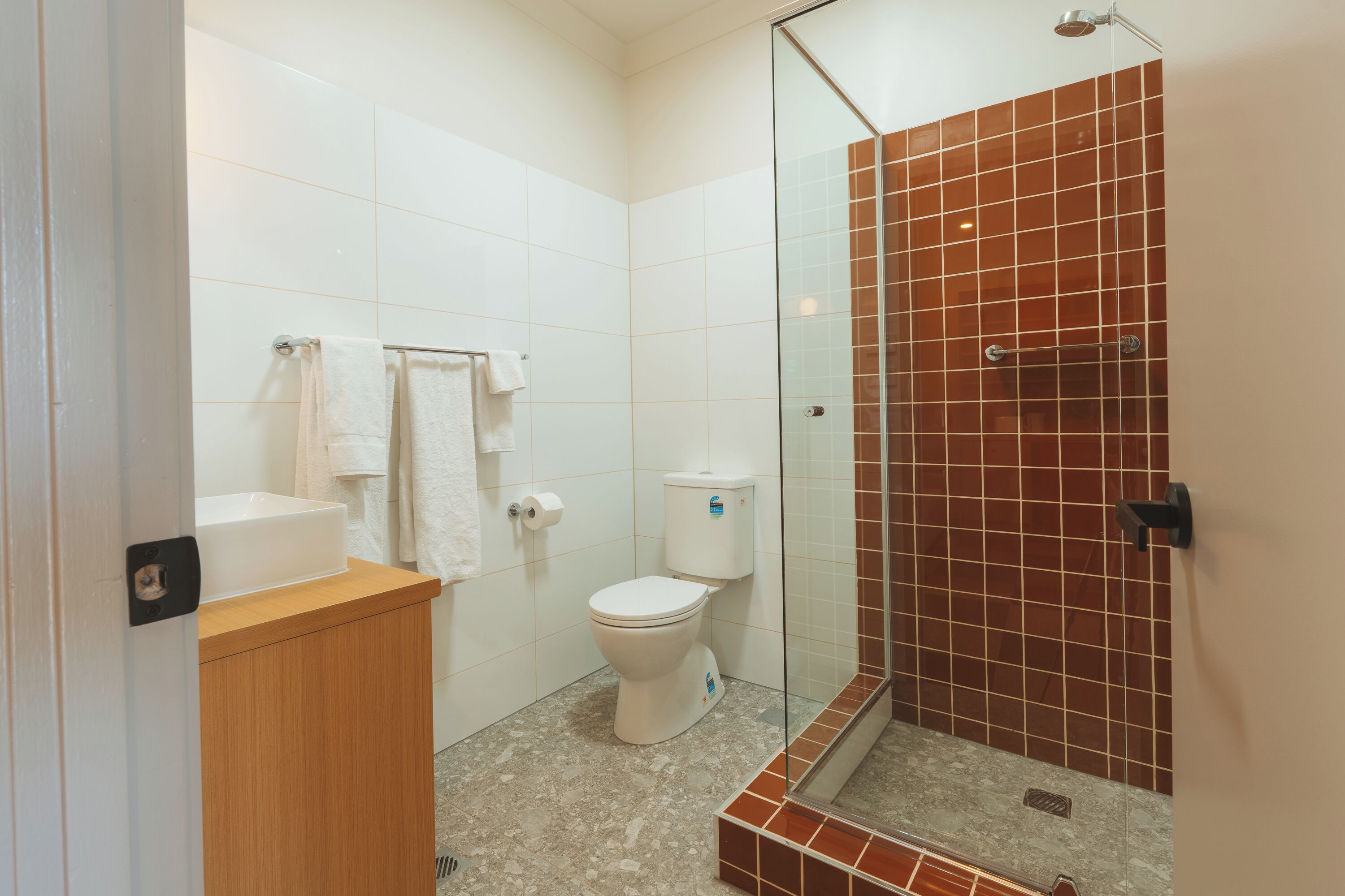 Ein Badezimmer mit Toilette, Waschbecken und einer Duschkabine.