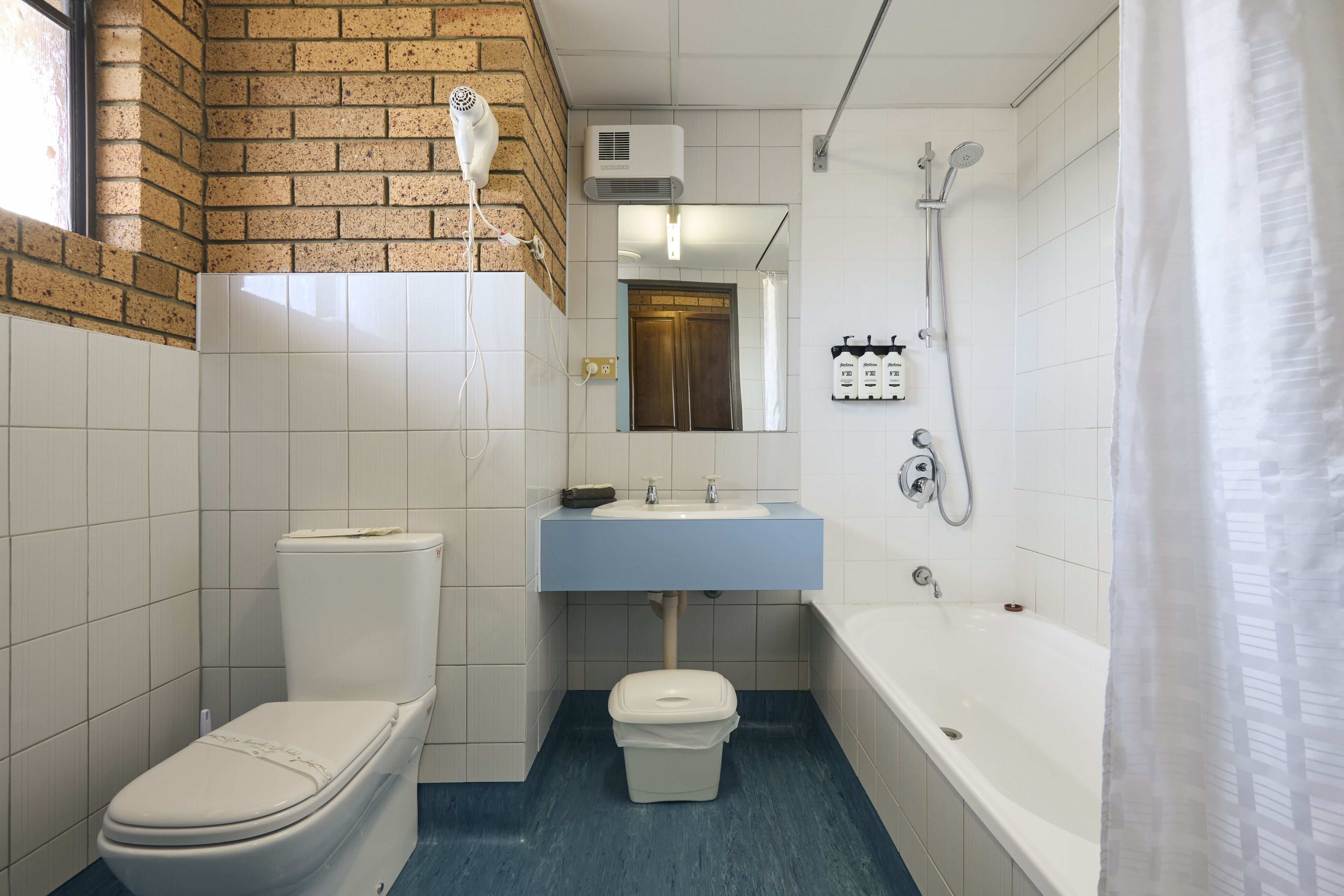 A bathroom with a toilet, sink, and bathtub.