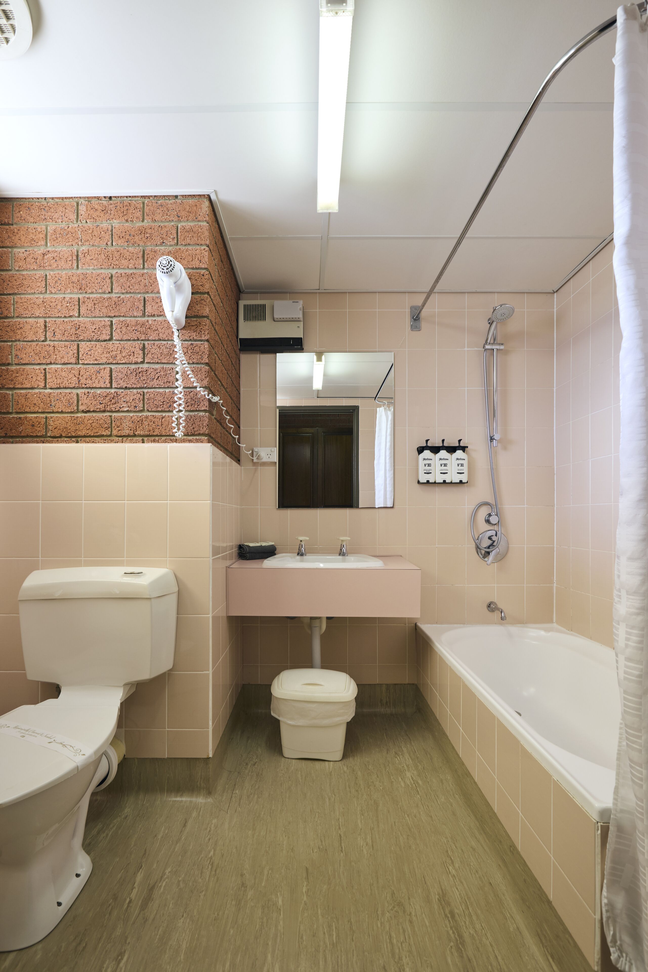 Une salle de bain avec des toilettes, un lavabo et une baignoire.