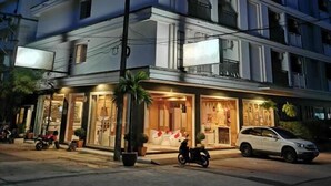 A multi-story hotel with balconies, a ground-level restaurant, and a street view. - Patong Princess (Patong)