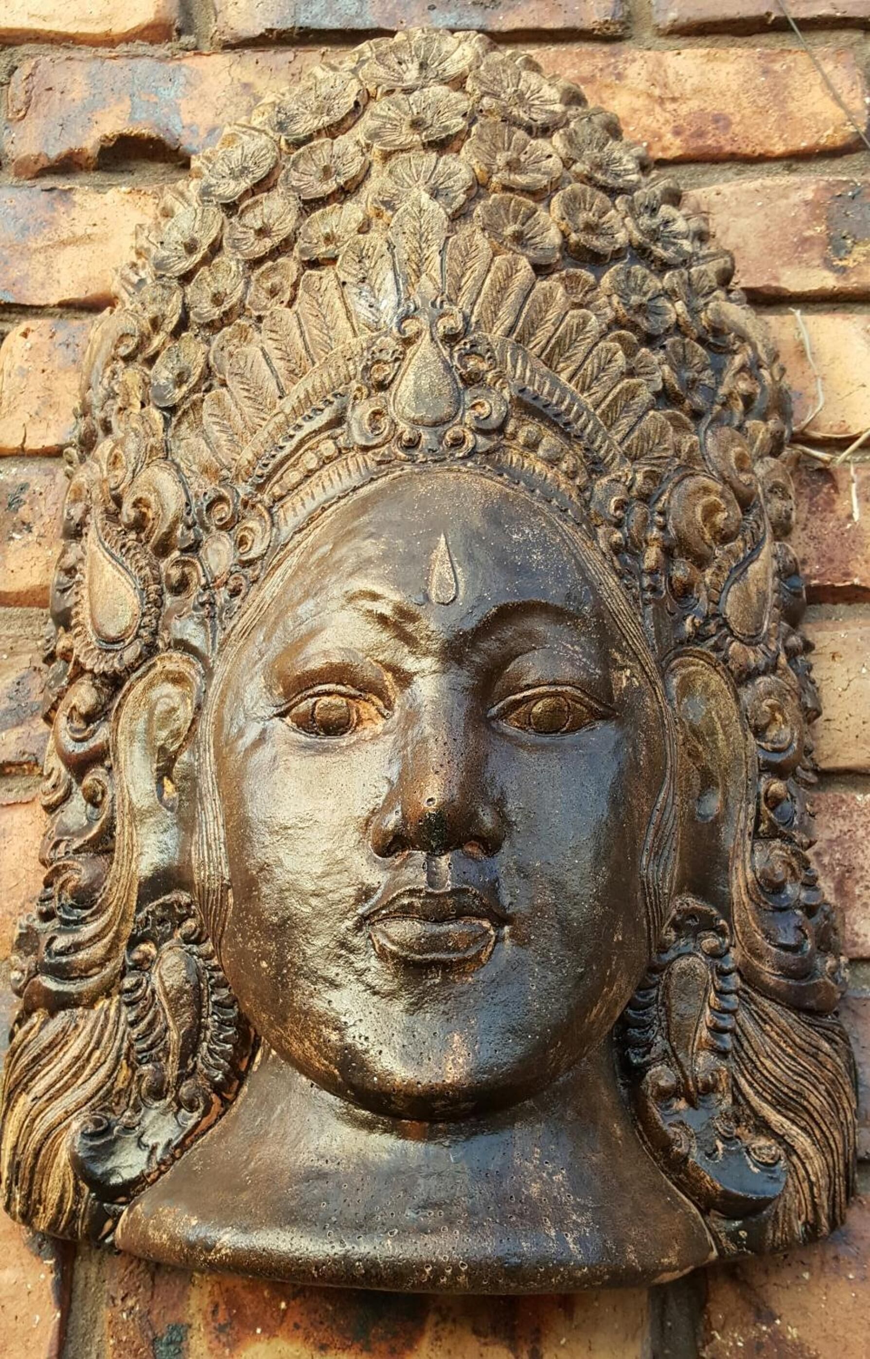 A detailed stone carving with intricate patterns and a central figure.