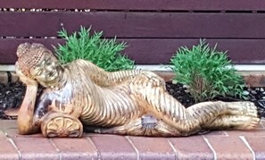 Une sculpture décorative représentant un lézard allongé sur une surface en briques.