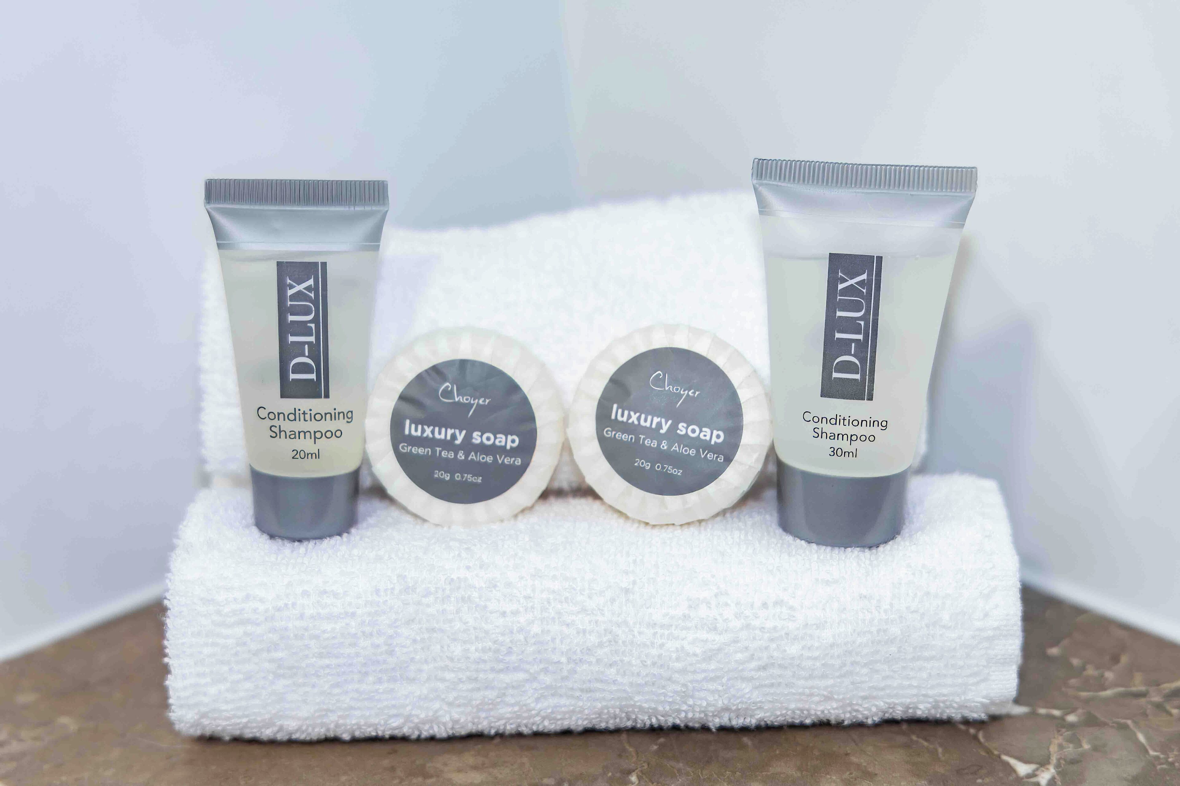 Three D-Lux products: Conditioning Shampoo, Luxury Soap, and Conditioning Shampoo, each with different volumes.