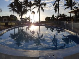 Una piscina al aire libre, sillones reclinables de piscina