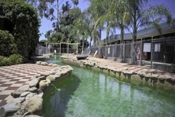 Una piscina al aire libre, sillones reclinables de piscina