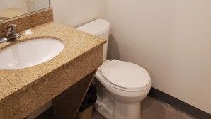 Un baño con lavamanos, inodoro y toallero.