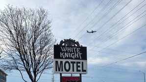 Señal de motel con un logotipo de caballero y el nombre 'White Knight Motel'.