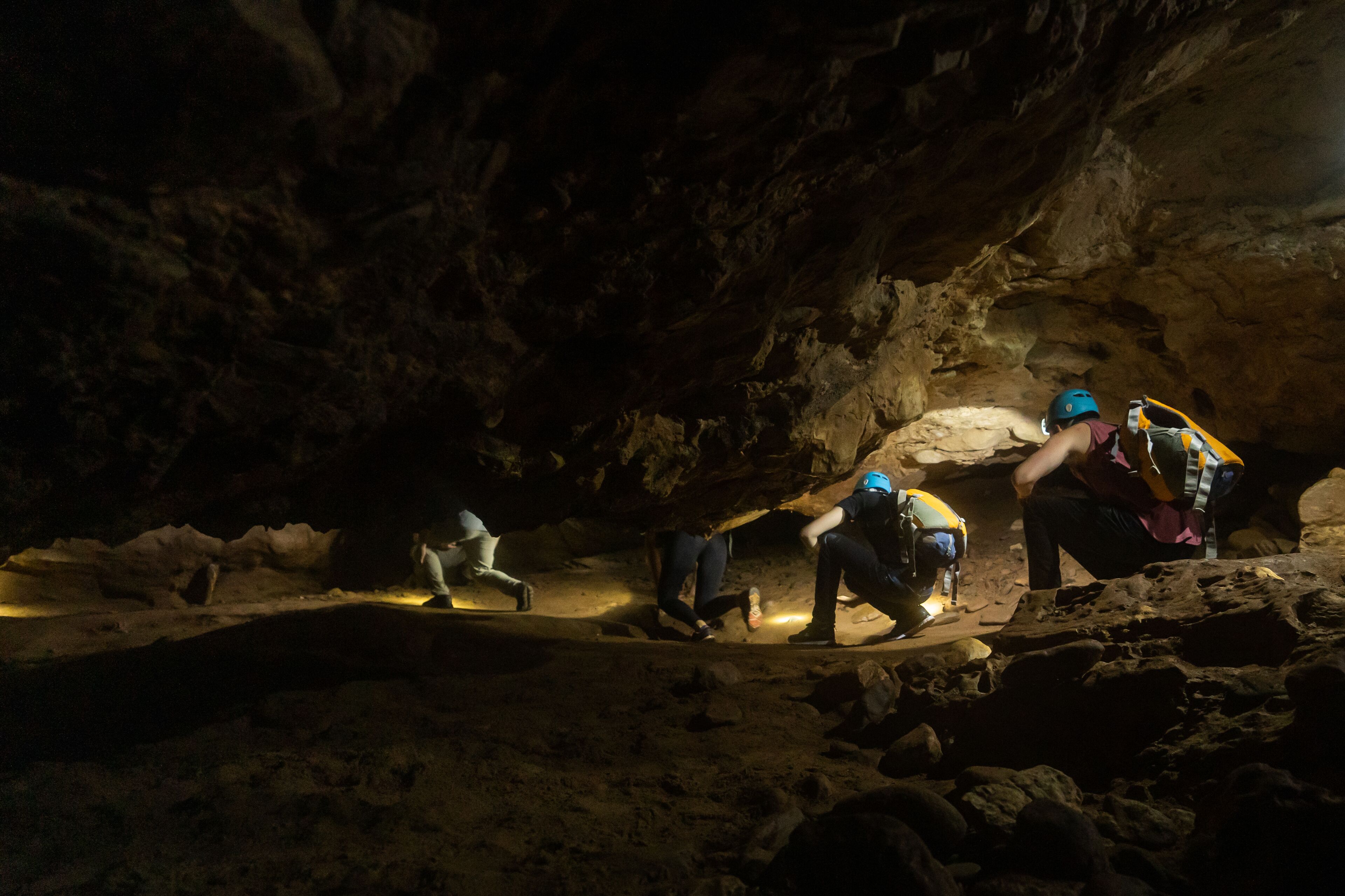 Un grupo de personas en una cueva con iluminación artificial.