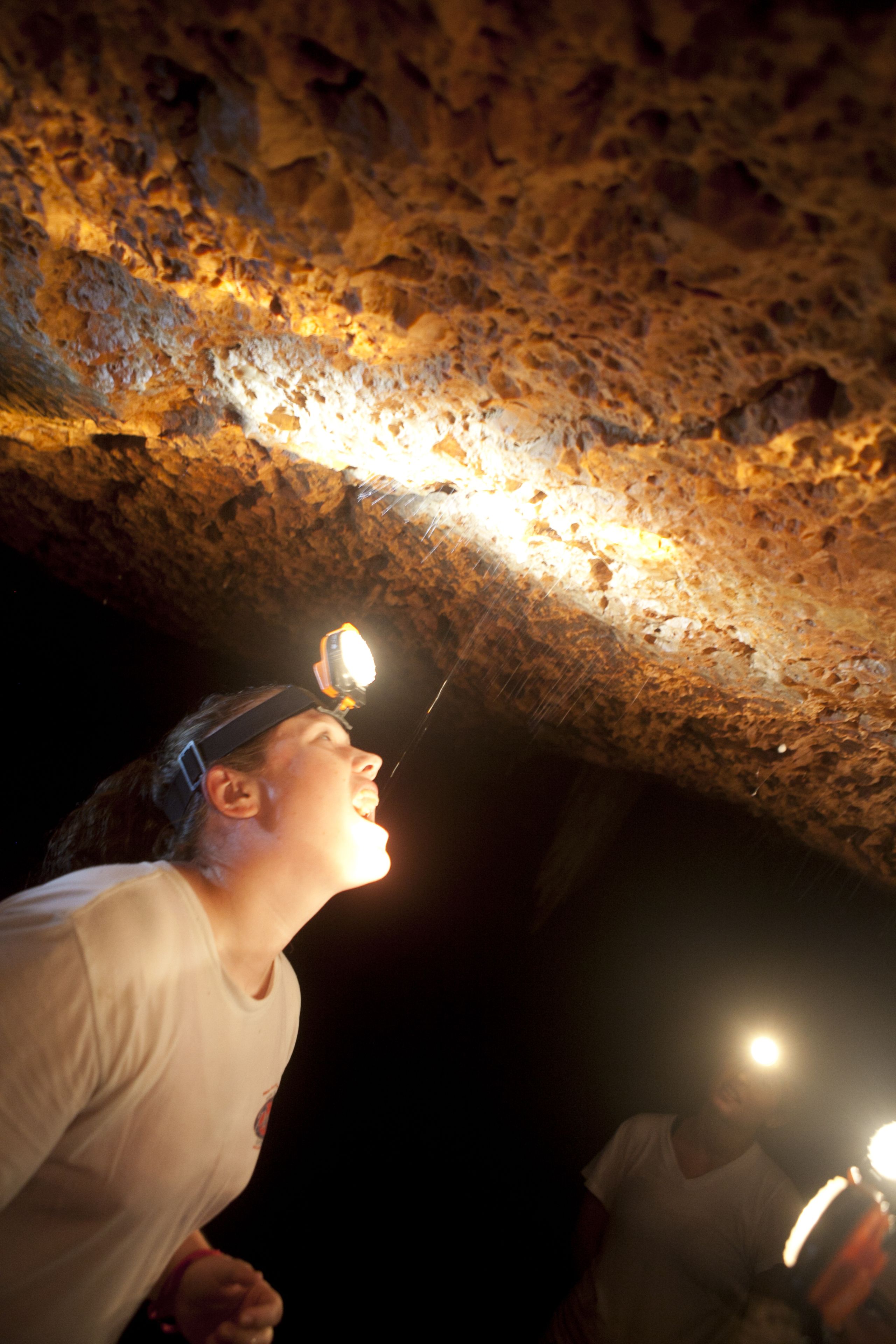 A person holding a light source in a cave.