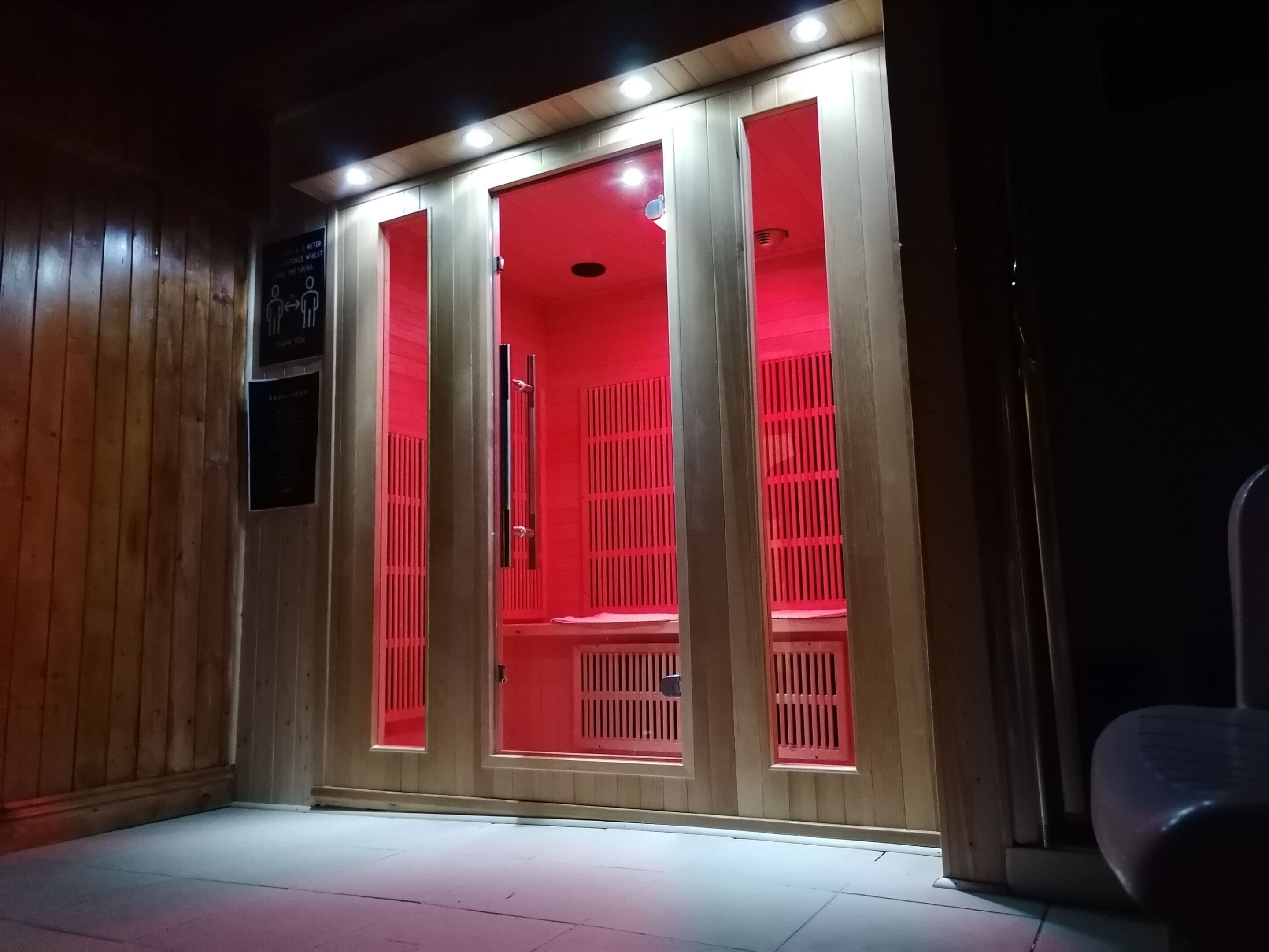 A room with wooden paneling, a red-lit cabinet, and a white floor.