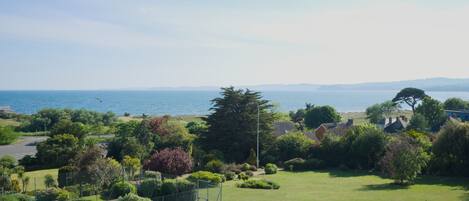 Quartiere residenziale con vista sul mare, case e un campo da tennis.