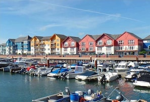 A marina with colorful buildings and boats docked.