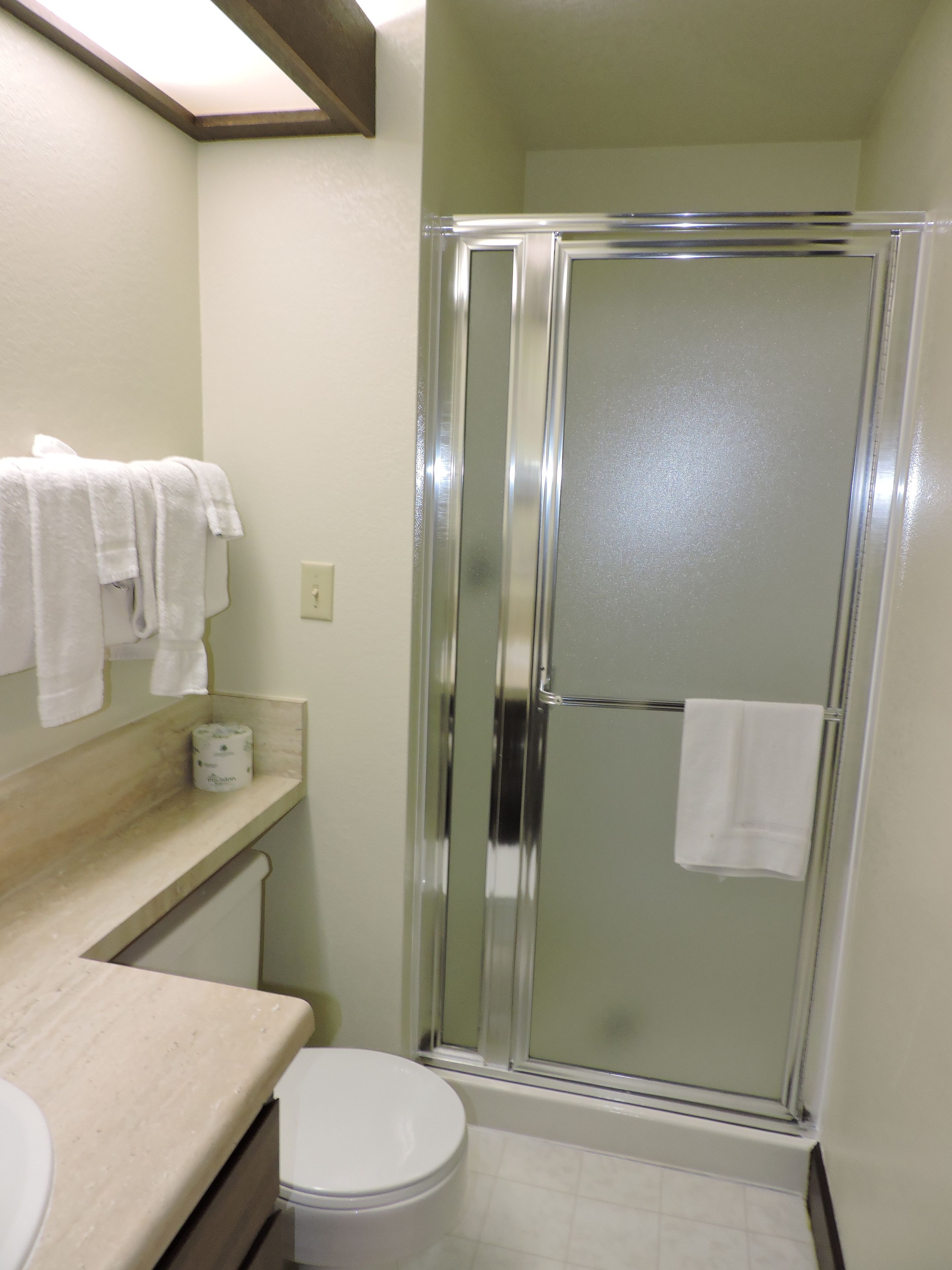 Un baño con ducha, inodoro y lavamanos.