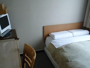 A hotel room with a bed, a wooden headboard, a desk with a computer monitor, and a chair. - Hotel Mates Asahikawa (Asahikawa)