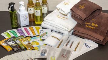 A variety of toiletries and towels, including face and hand soap, shampoo, and bath products, arranged on a table.