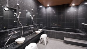 Un baño moderno con un espejo grande, un lavabo, un inodoro y una zona de ducha.
