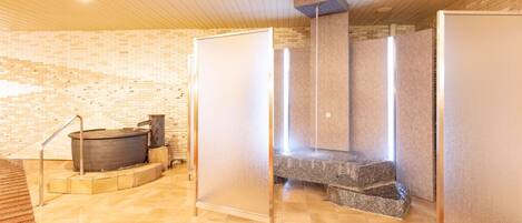 A spa area with a hot tub, a stone bench, and a sauna.