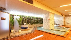 A modern indoor pool area with a wooden ceiling, a brick wall, and a tiled floor. - Hanamaki Onsen Hotel Senshukaku (Hanamaki)