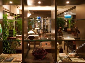 A modern interior with glass partitions, a dining area with a table and chairs, and various decorative items. - Green Hotel Morris (Tottori)