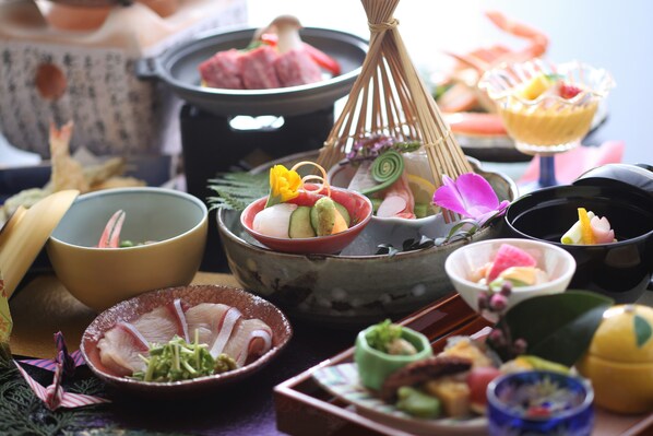 A variety of Japanese dishes, including sushi and sashimi, arranged on a table with traditional bowls and chopsticks. - Yukibou Hakusen (Yonago)
