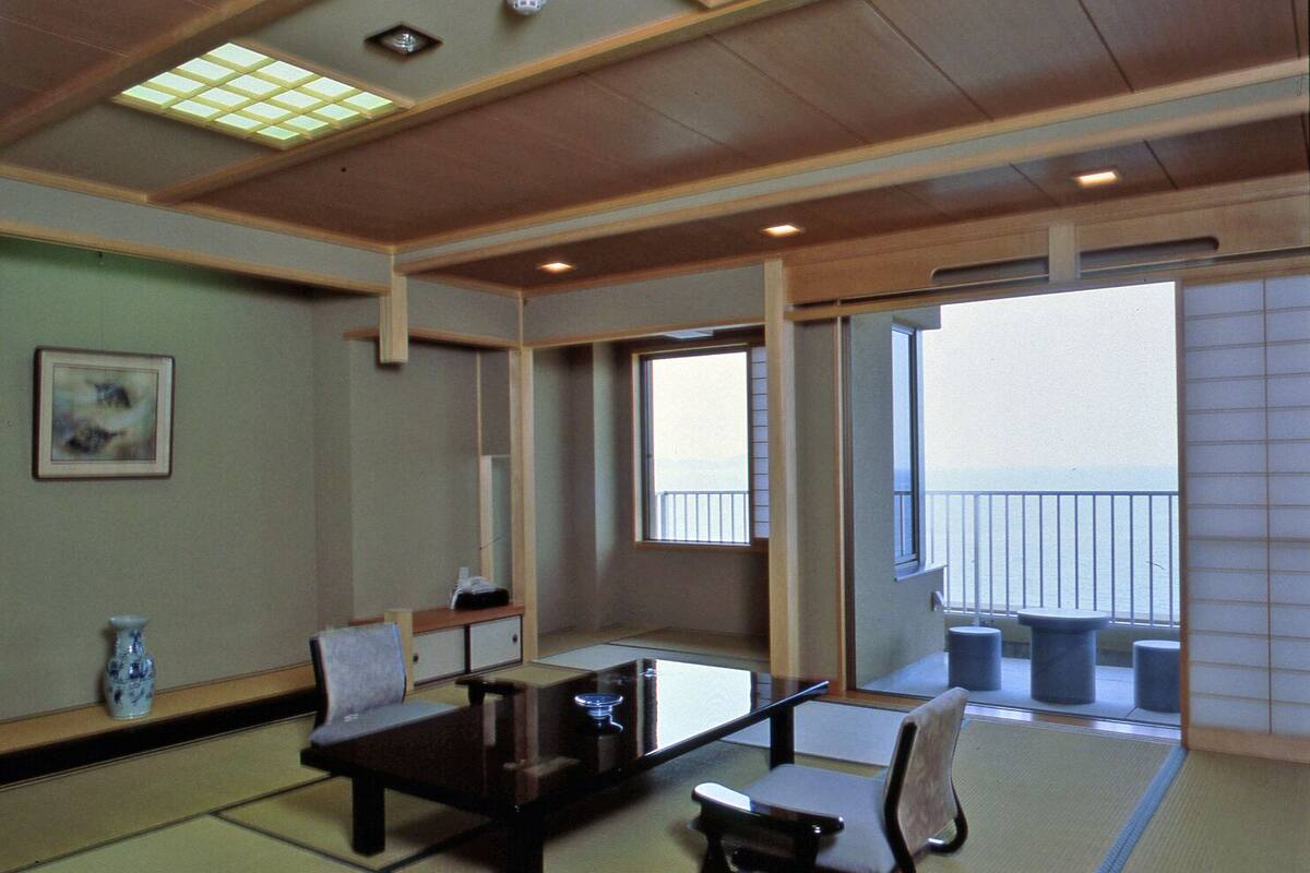 A traditional Japanese-style room with tatami flooring, a low table, and a sofa.