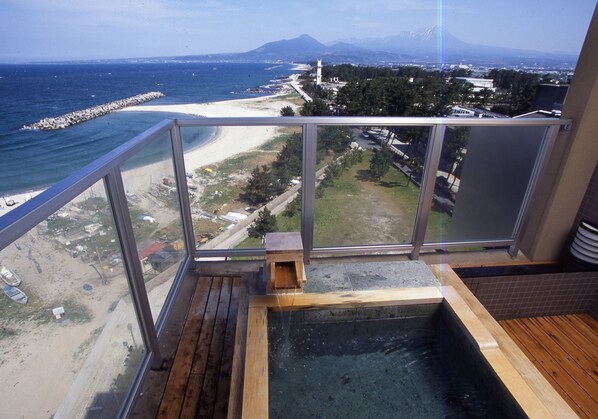 A hot tub with a wooden deck and a view of a beach and mountains. - Yukibou Hakusen (Yonago)