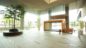 A spacious lobby with a large glass entrance, seating areas, and potted plants. - Katayamazu Onsen Tokigasane (Kaga)