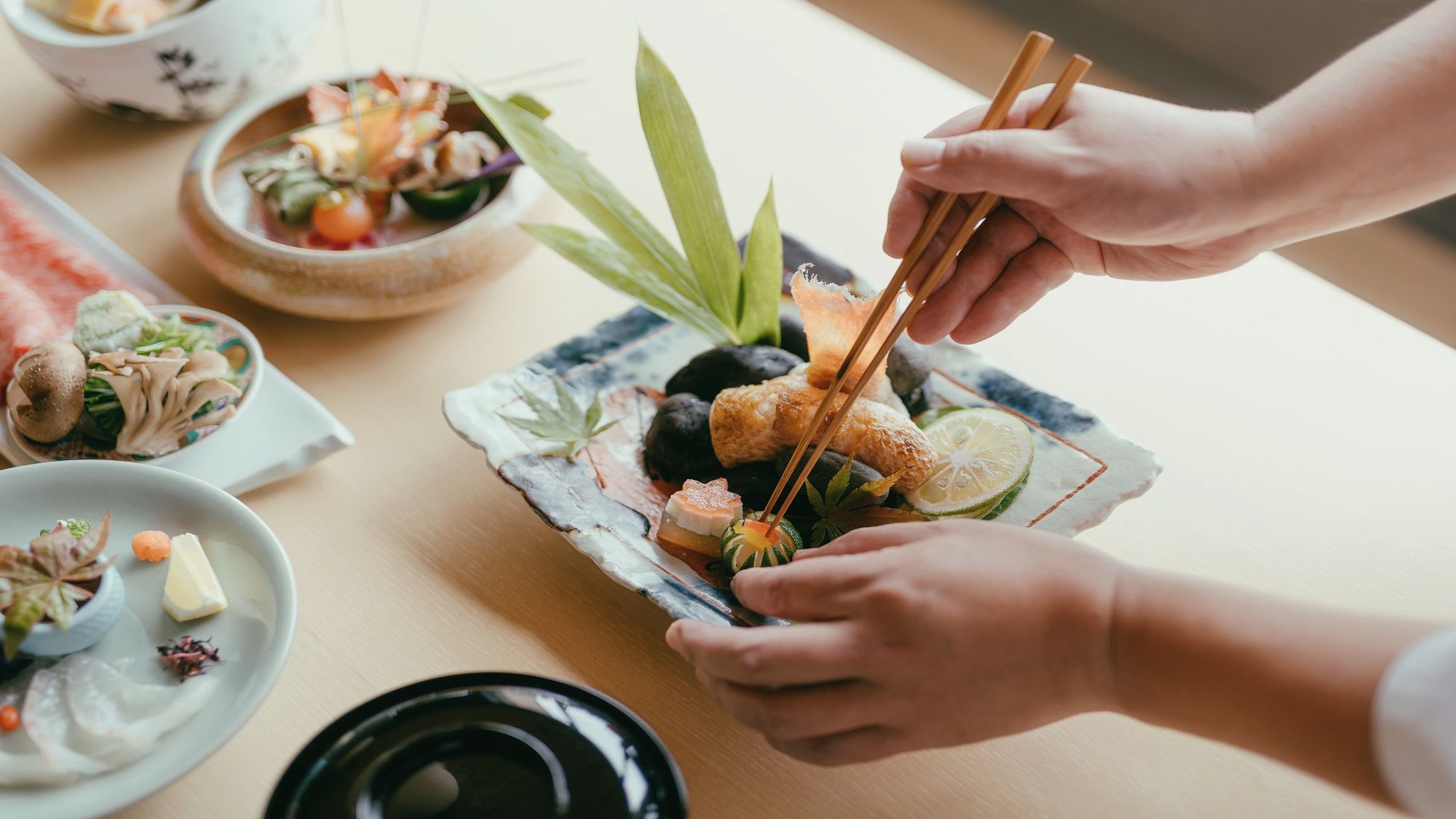 Una mesa de comedor con diversos platos, como sushi, verduras y un tazón de sopa.