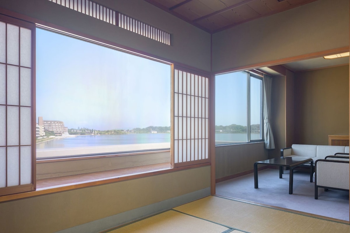 A traditional Japanese room with tatami flooring, a low table, and a sofa.