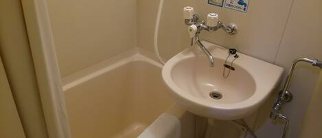 A bathroom with a bathtub, a sink, and a shower.