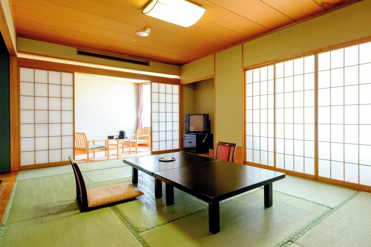 A traditional Japanese room with tatami flooring, a low table, and sliding doors.