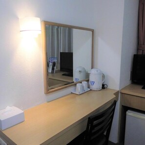 A hotel room with a desk, a mirror, a coffee maker, and a television. - Olympic Inn Shibuya (Tokyo)