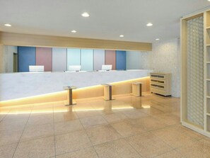 A reception area with a counter, seating, and a patterned wall. - Smile Hotel Atsugi (Atsugi)