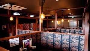 A restaurant with wooden booths, patterned wall tiles, and hanging pendant lights. - Matsue Plaza Hotel Honkan (Matsue)