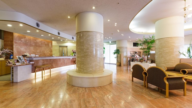 A spacious lobby with a reception desk, seating area, and a kitchen in the background. - Kochi Pacific Hotel (Kochi)