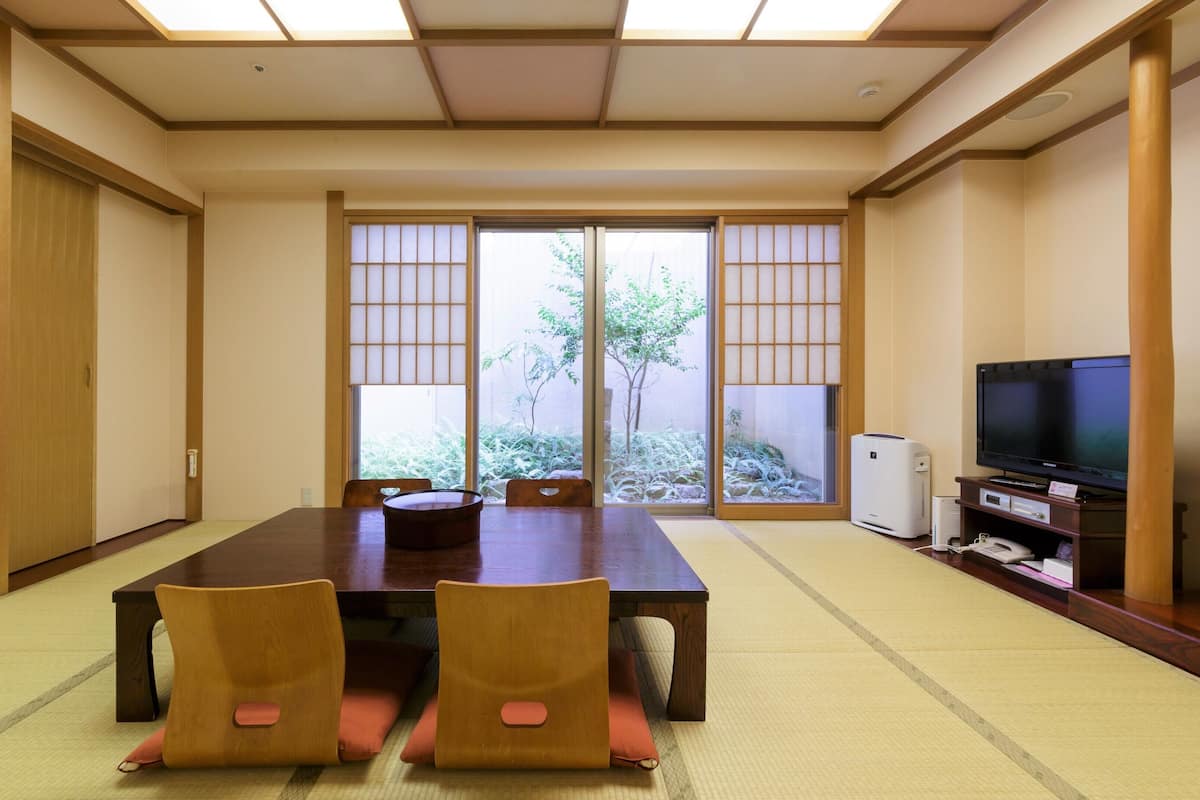 Una tradizionale stanza in stile giapponese, con pavimento in tatami, un tavolino basso e porte scorrevoli.