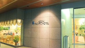 The exterior of the Kochi Pacific Hotel with a reception area visible through the glass doors. - Kochi Pacific Hotel (Kochi)