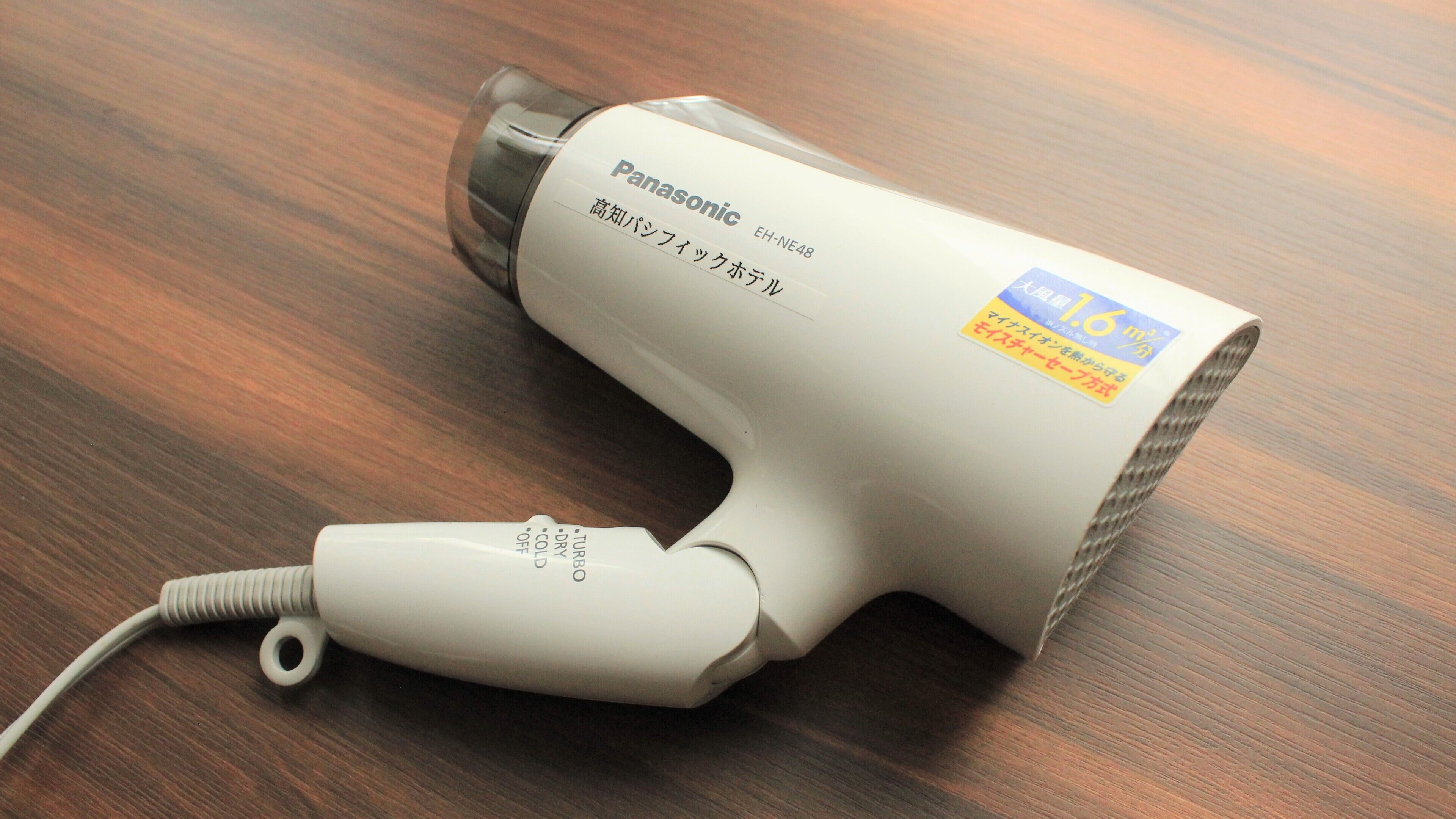 Een Panasonic haardroger op een houten oppervlak.