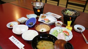 Ein Tisch mit verschiedenen Speisen, darunter Reis, Suppe und einem Hot Pot.
