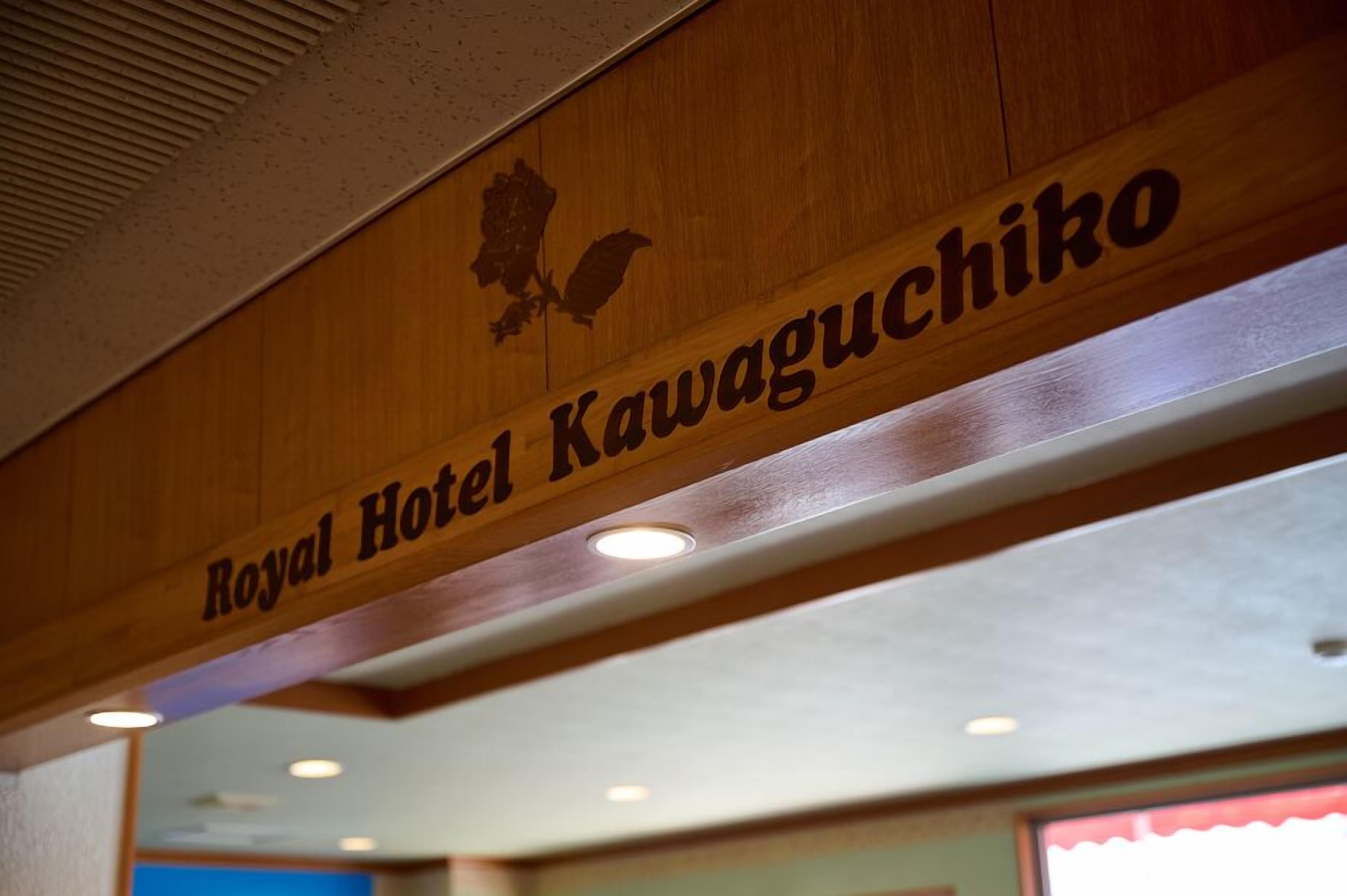Ein hölzernes Schild mit dem Aufschrift 'Royal Hotel Kawaguchiko' und einer Vogelkontur.