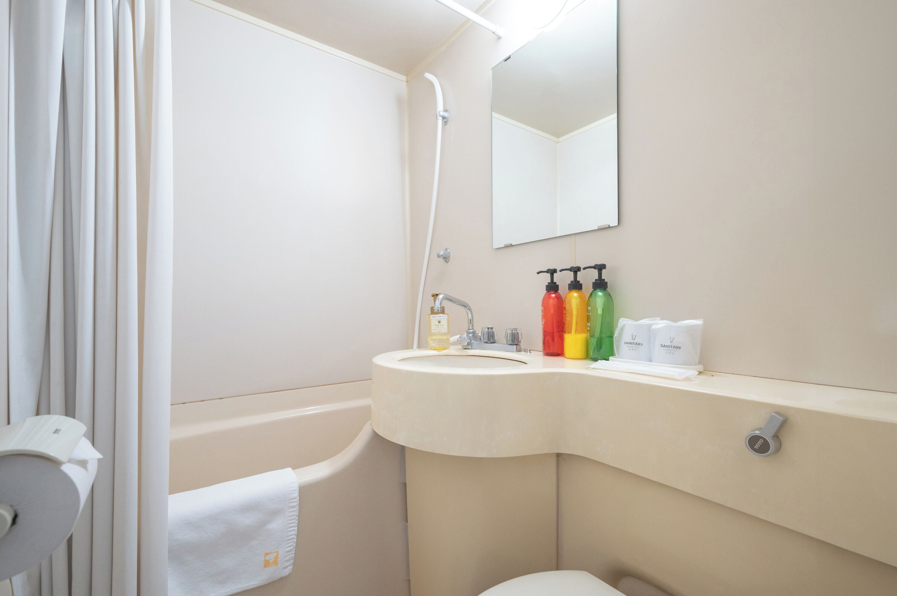 A bathroom with a sink, mirror, and toiletries.